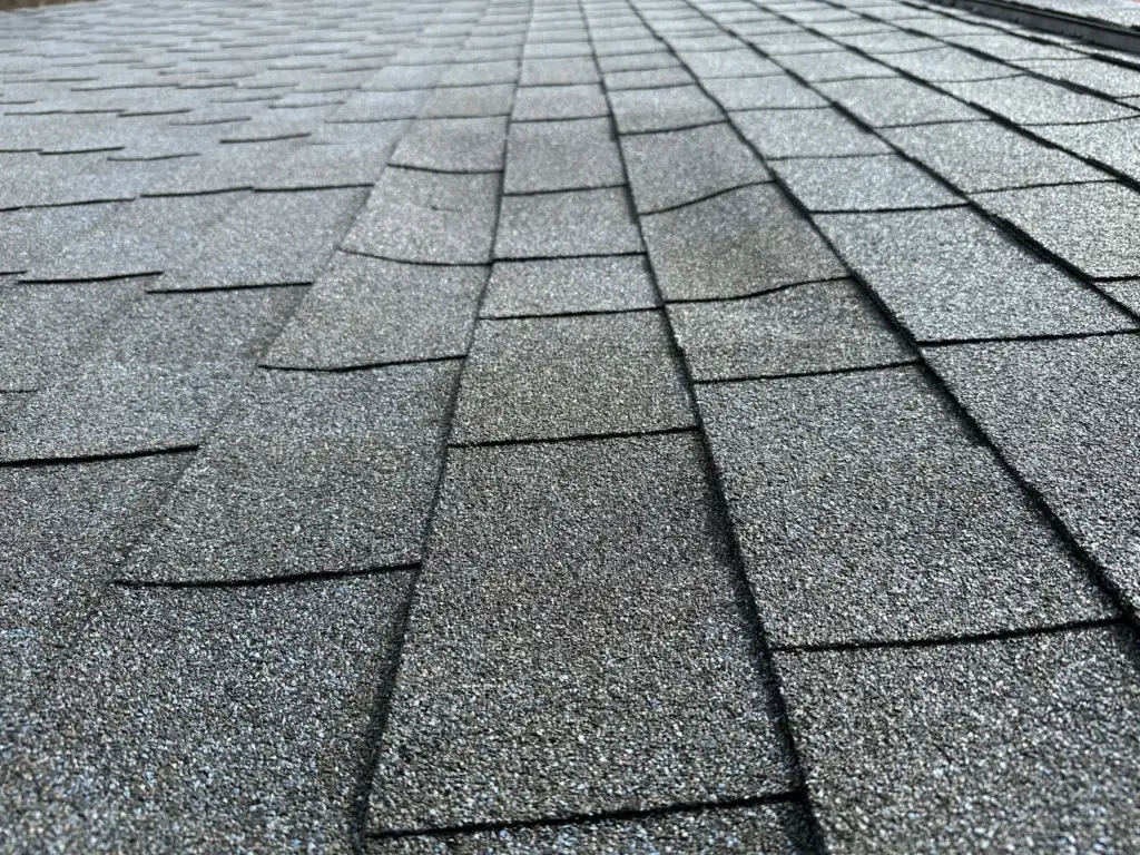 This image highlights a roof requiring prompt repair, showcasing damaged and weathered asphalt shingles with visible cracks, gaps and discoloration. Gold Medal Roofing's expert technicians will assess and restore this roof's integrity, ensuring a secure, watertight seal and renewed protection.