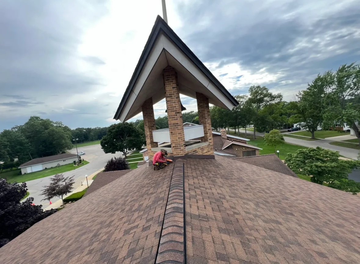 Our skilled roofing crew meticulously installs architectural shingles on a expansive commercial church, showcasing expertise and attention to detail.