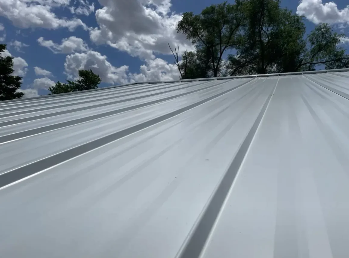 Professional metal roofing contractors install sleek, modern grey standing seam systems with precision.